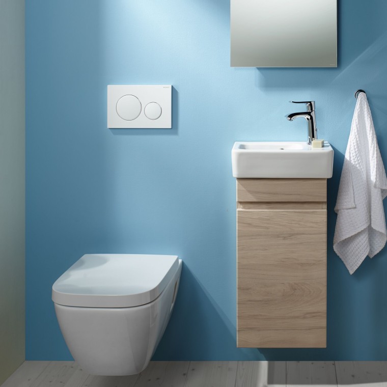 Závěsné WC Selnova a prostor s umyvadlem na světle modré stěně. Závěsné WC Selnova a prostor s umyvadlem na světle modré stěně.